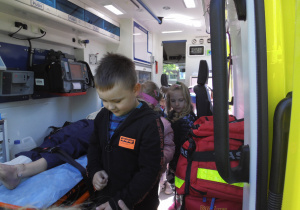 Ratownicy medyczni na terenie przedszkola prezentują wyposażenie i przeznaczenie sprzętu w jaki jest wyposażony ambulans